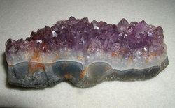 A bed of amethyst crystals on base rock, 13cm (5in) long