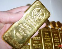 Gold bars with Krugerrands in the background.