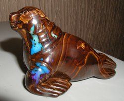 Boulder opal carving of a walrus, showing flashes of colour from the exposed opal. The carving is 9 cm (3.5 inches) long.