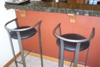 Two modern bar stools in front of a kitchen counter