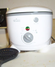 A domestic deep fryer with a slotted spoon