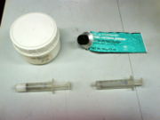 Grease is used to lubricate glass stopcocks and joints. Some laboratories fill them into syringes for easy application.  Two typical examples: Left - Krytox, a fluoroether-based grease; Right - a silicone-based high vacuum grease by Dow Corning.