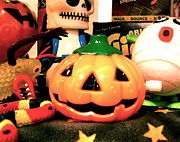 A toy Jack-o'-lantern sits among an array of other Halloween items.