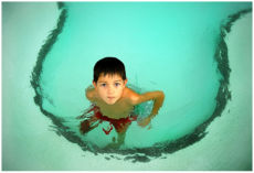 A boy in a shallow children's pool.