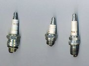 Three different sizes of spark plug. The leftmost plug and center plug are identical in threading and electrodes and may be used interchangably; the center plug is, however, a compact variant, with smaller hex and porcelain portions outside the head, to be used where space is limited. The rightmost plug has a longer threaded portion, to be used in a thicker head