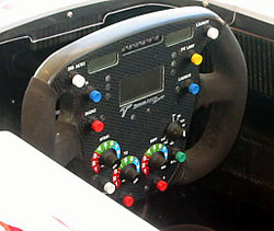 A modern Formula One car's steering wheel has buttons and knobs to control various functions