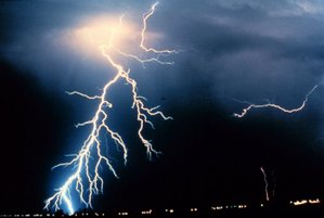 Lightning strikes during a night-time thunderstorm.  Energy is radiated as light as the air of Earth's atmosphere is shifted from gas to plasma and back.