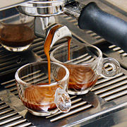 Espresso brewing, with a dark reddish-brown foam, called crema or schiuma.