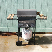 A single-burner propane gas grill that conforms to the cart grill design common among gas grills.