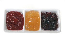 Three varieties of fruit preserves: strawberry, quince, and red plum