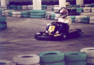 A kart racer takes a turn on an indoor track