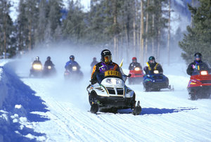A snowmobile tour at Yellowstone National Park, note the snowdust in the air (NPS Photo)